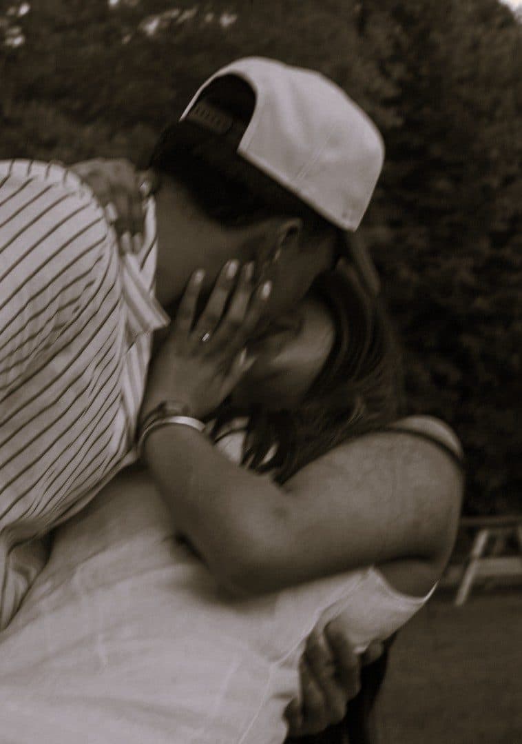 A black and white photograph of a couple sharing a quiet kiss
